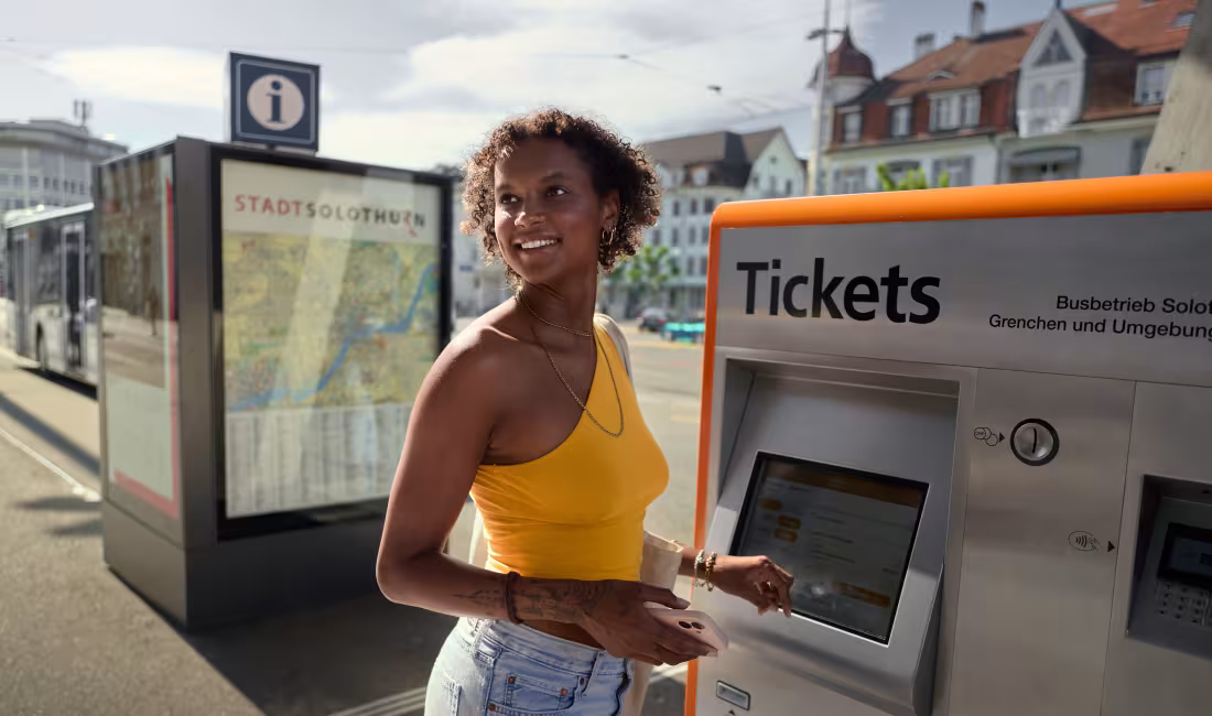 Fahrgast kauft am Ticketautomaten ein Ticket und informiert sich über Kontakte und Standorte von AREMO.