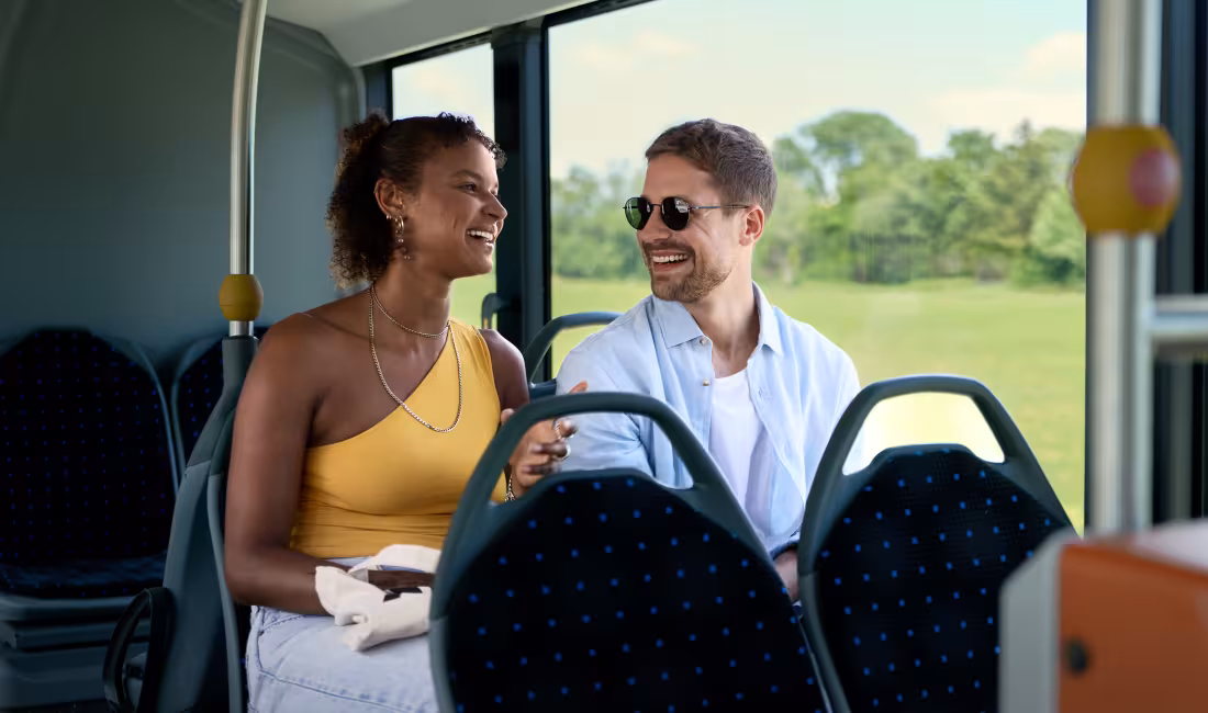 Fahrgäste fahren mit dem Bus von AREMO durch die Region und unterhalten sich während der Fahrt.